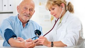 Female doctor measuring blood pressure of senior man